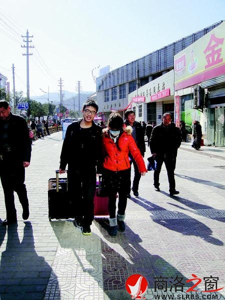 一對情侶模樣的人,一人拖一個拉桿箱