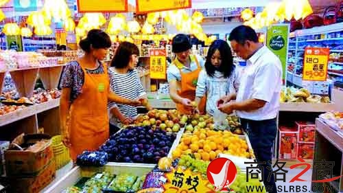 環(huán)境優(yōu)美的水果專賣店里,店員耐心地幫著顧客挑選水果。